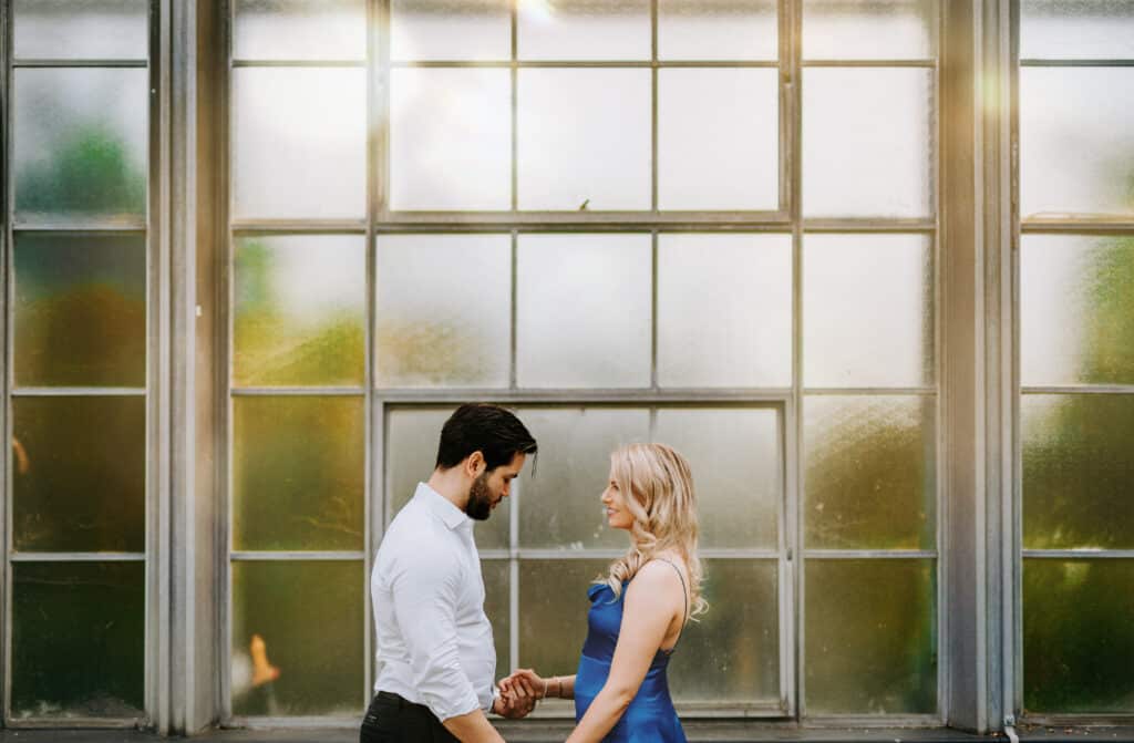 Steve Bridgwood Engaged couple holding hands by a foggy glass wall